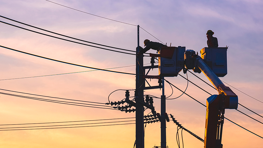 Utility workers fixing wire on pole