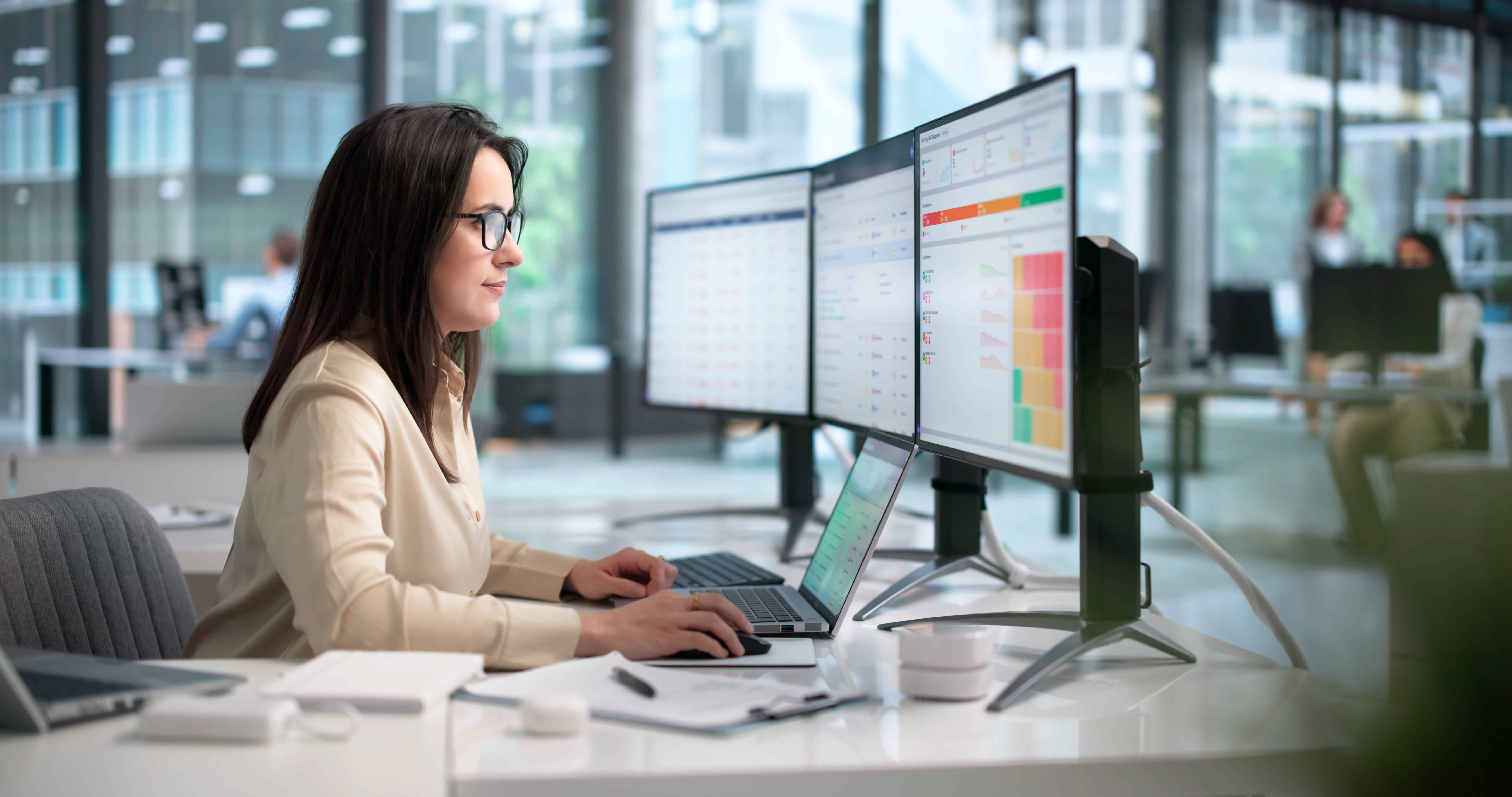 Woman looking at reports on multiple screens
