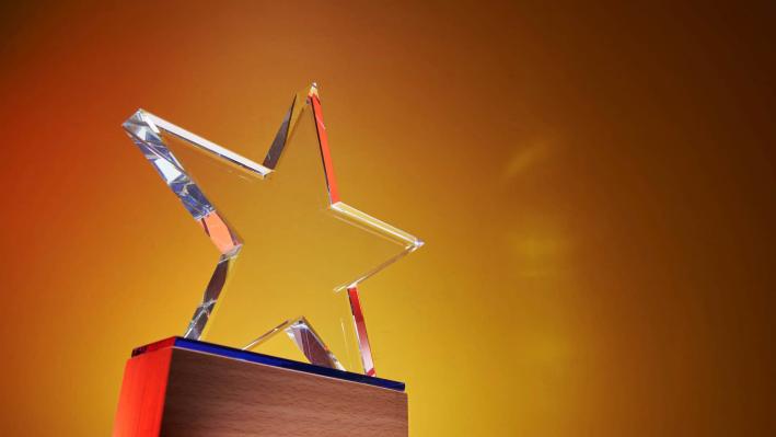 Image of an award shaped like a star on a gold background. 