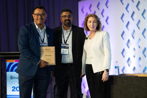 Attendees accepting the Website Benchmark Award of Excellence at Forum.