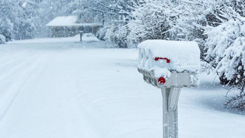 Mailbox covered in snow on a snowy roadside