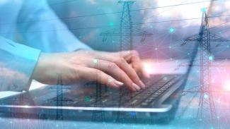 Hands typing on laptop with overlay of power lines and digital network